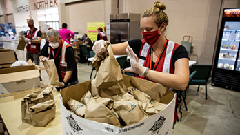 Woman Red Cross relief worker fills emergency food boxes for wildfire evacuees